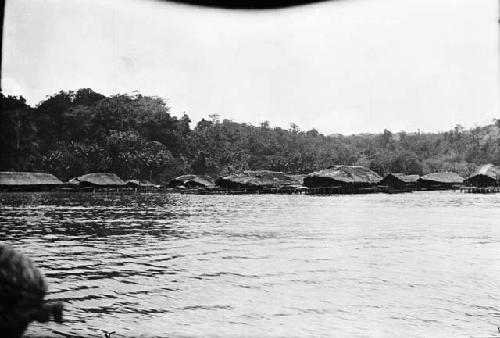 Raised Huts over river with docks and a boat