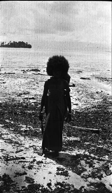 Woman standing on beach with child