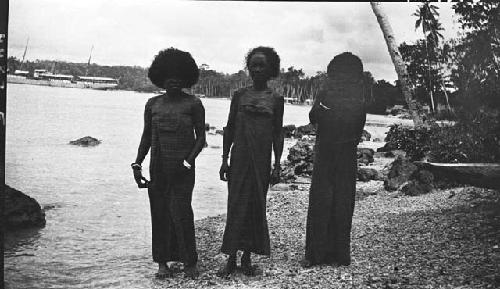 Three women standing on the beach