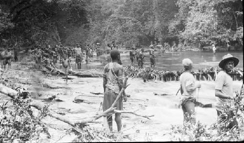 Group gathered near stream waiting for fish