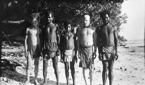 Group of men standing in a row along shore