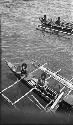 Men rowing a double outrigger dugout canoe