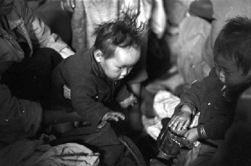 Portrait of babies playing with the can