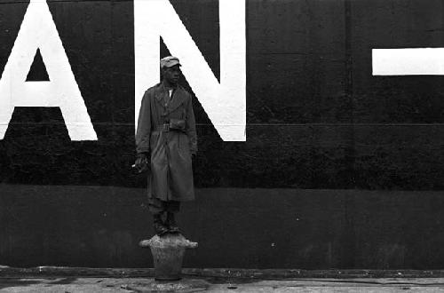 Officer standing on bucket outside next to boat