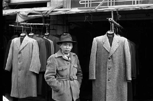 Man standing by coat racks