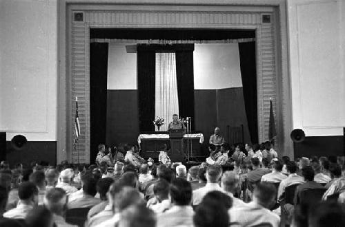 Soldier at podium adressing soldiers in auditorium