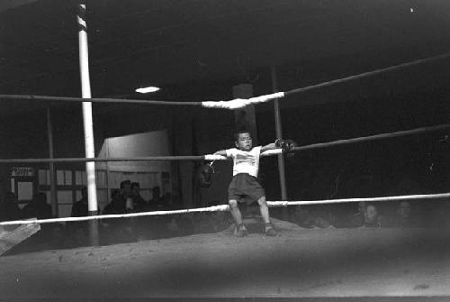 Kid sitting in corner against rope