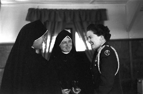 Portrait of nuns and soldier shaking hands