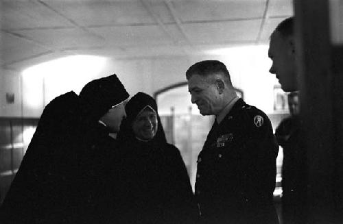 Portrait of nuns making conversation with genral