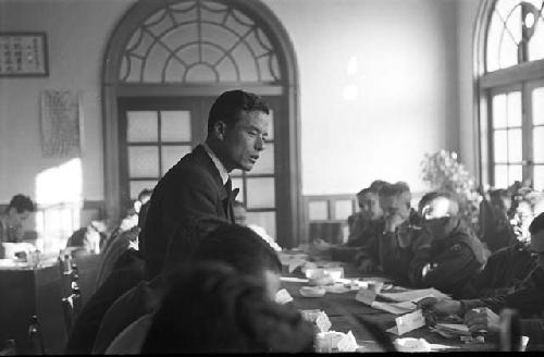 Man at table speaking up during meeting