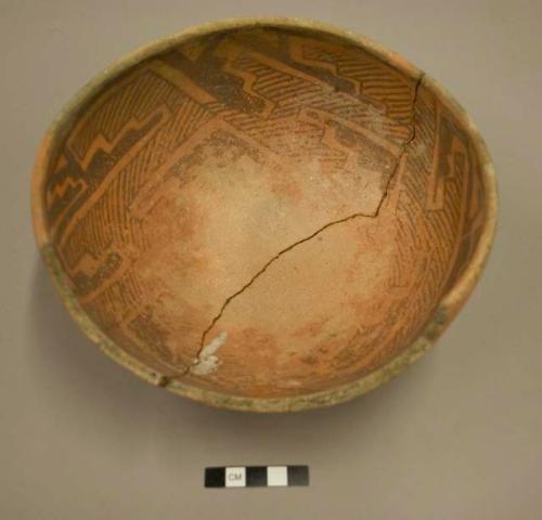 Ceramic bowl, white on orange exterior, black on orange interior, mended