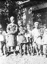 6 barefoot boys standing in front of building