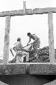 Two men hauling nets in front of wooden altar