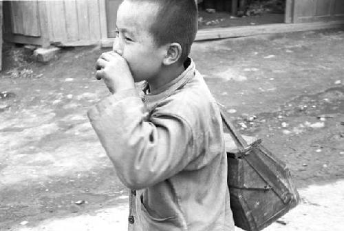 Boy nibbling hand as he walks