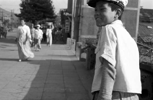 Portrait of boy walking down sidewalk