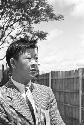 Portrait of man wearing suit, fence in background