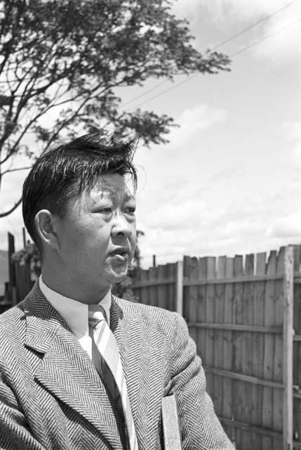 Portrait of man wearing suit, fence in background