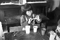 Girl sitting at table playing with card