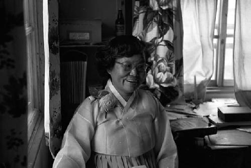 Portrait of woman standing by window happy