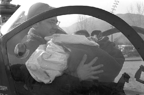 Soldier holding baby in chopper