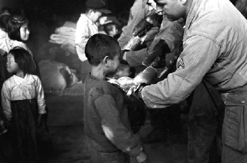 U.S. soldier spraying child with insecticide