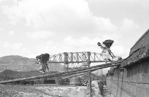 Workers hauling rocks off boat