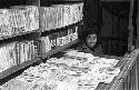 Woman sitting by book stand