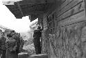 Portrait of soldiers in street peeking into house 2