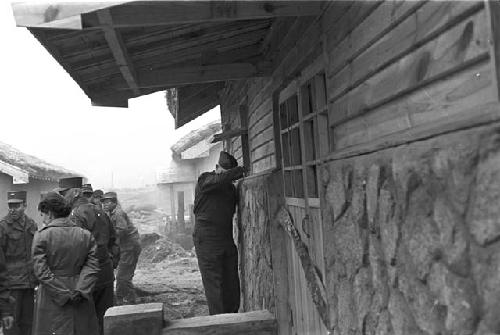 Portrait of soldiers in street peeking into house 2