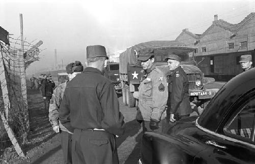 Portrait of soldiers on side of road as trucks pass by