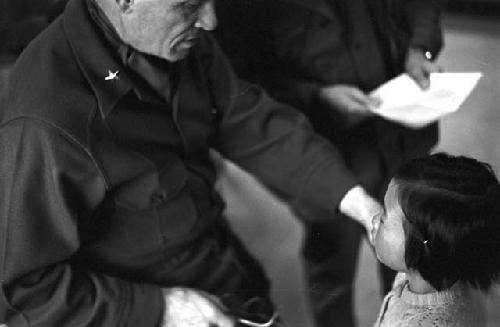 Portrait of general giving young girl a pat