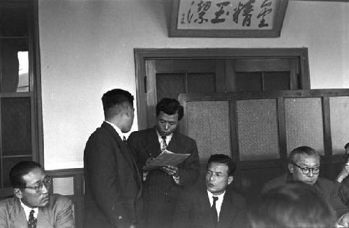 Man in suit interrupted while addressing participants