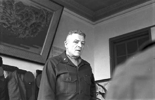 Portrait of general at head of table speaking