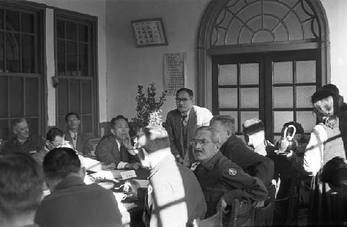 Portrait of soldiers and suits sitting down at table