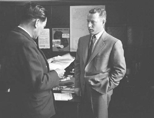 Men in suits meeting with each other going over letter