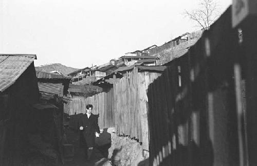 Man walking down path behind homes