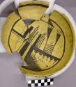 Partial restored brown on yellow bowl with outer geometric, inner figurative