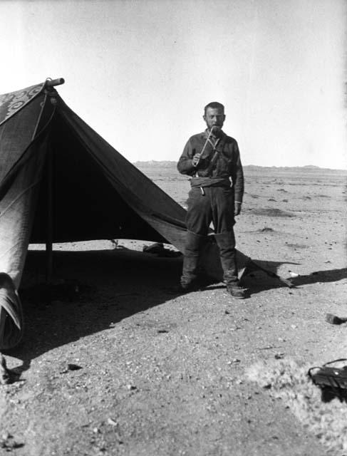 Owen Lattimore standing before tent near Mingshui