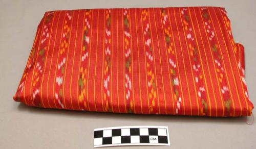 Fabric for woman's longyi; red ikat with yellow, white and green