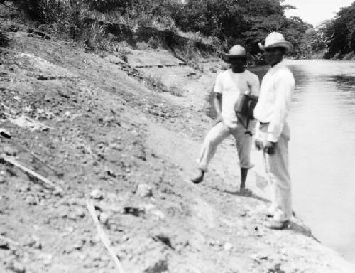 Men standing on riverbank at Cocle