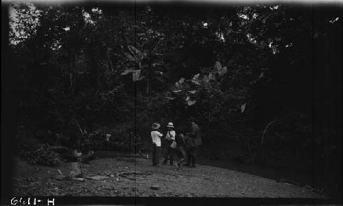 Men standing by river in jungle