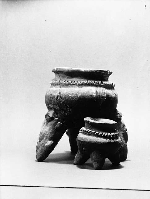 2 grey tripod jars with modelled decoration from grave 5, numbers 99, 112