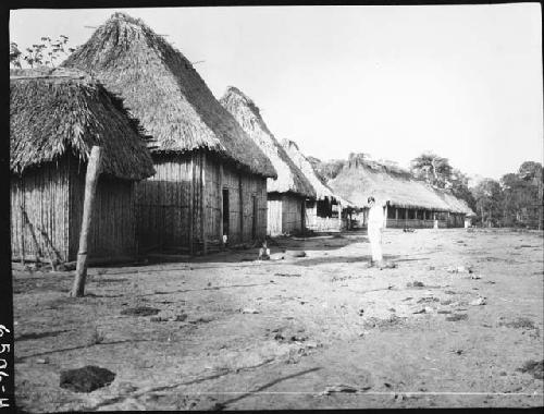 Man in front of several huts