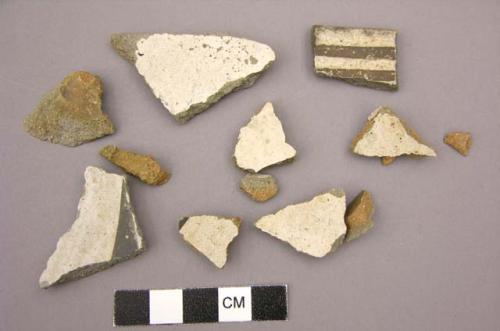 Ceramic sherds, body or rim, white interior, some with black designs, mended