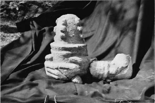 Sculpted arms and object held in hands on mound North of Castillo