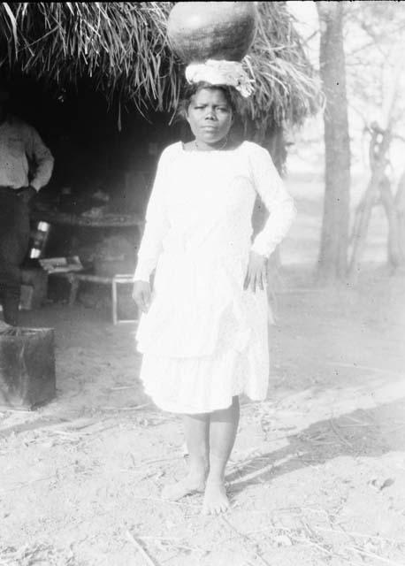 Native woman carrying vessel on head