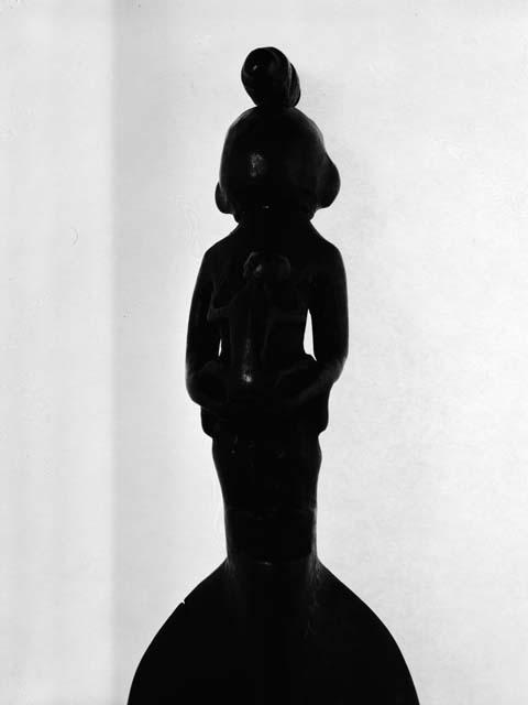 Spoon with woman carrying child on back and bundle on head