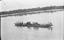 Men and animals on canoe in river