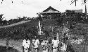 Four boys standing in front of a building on a hill