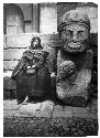 Woman sitting next to statue, Tiaquanaco
